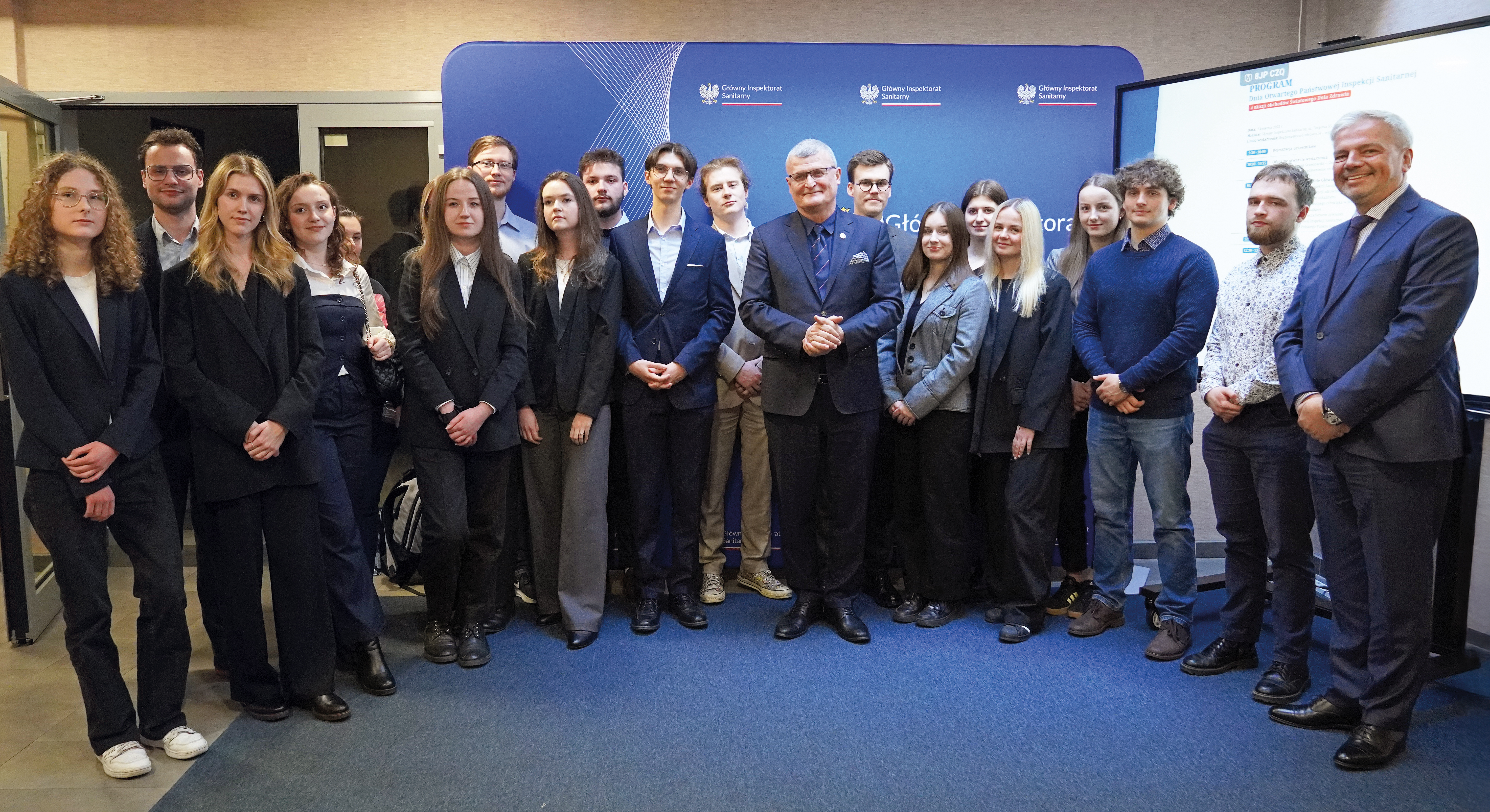 Studenci kierunku lekarskiego i uczestnicy na konferencji naukowej w Głównym Inspektoracie Sanitarnym ustawieni do zdjęcia.
