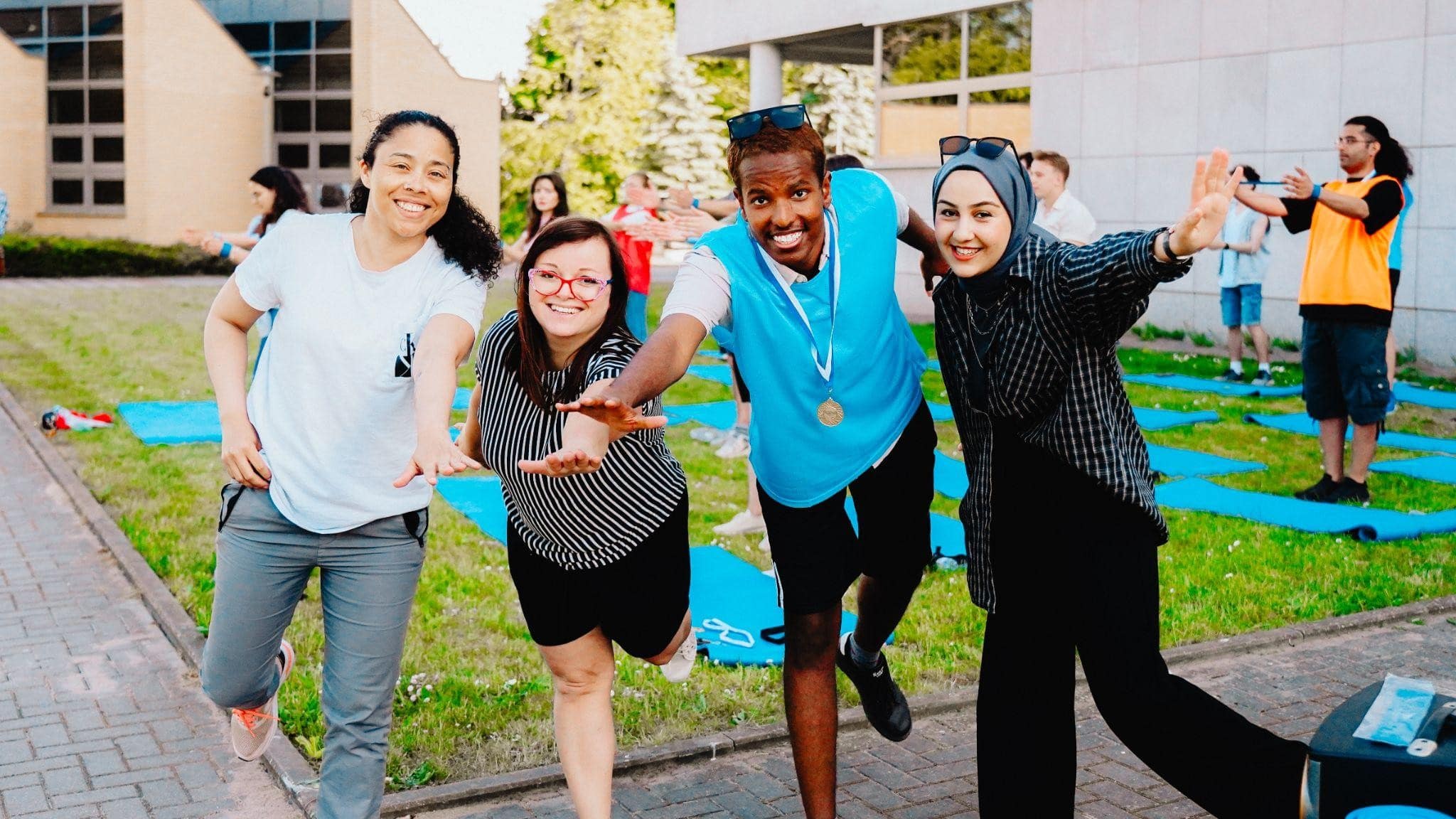 Studenci Erasmus+ pozują do zdjęcia z koordynatorką na świeżym powietrzu.
